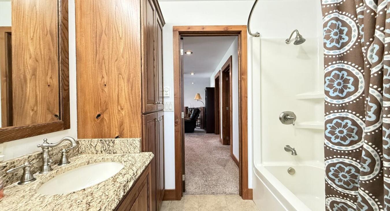 Bathroom #3 located upstairs equipped with shower/tub, toilet, and double sink.