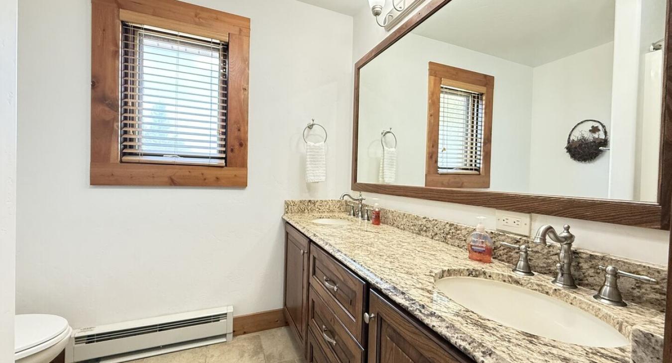 Bathroom #3 located upstairs equipped with shower/tub, toilet, and double sink.