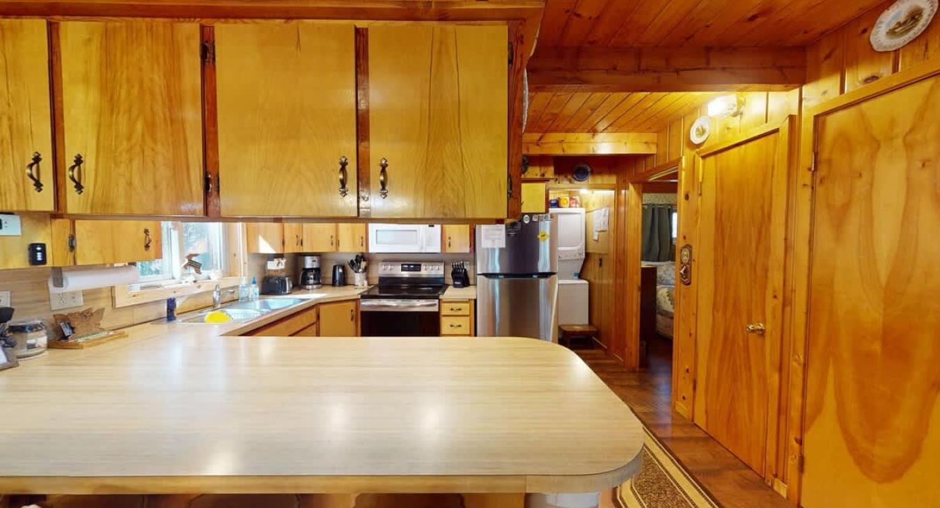 The full size kitchen is equipped with appliances, dishes, and basic cooking essentials.