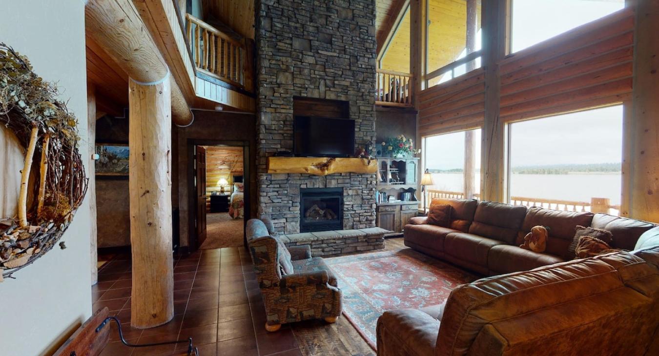 Living room is equipped with a beautiful fireplace, tv for entertainment, and plenty of seating for everyone.