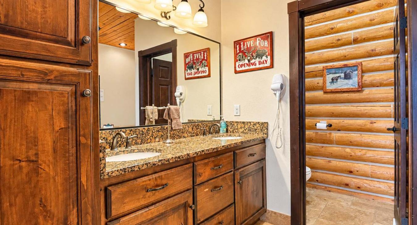 This bathroom is equipped with a walk in shower, toilet, and double sink vanity.