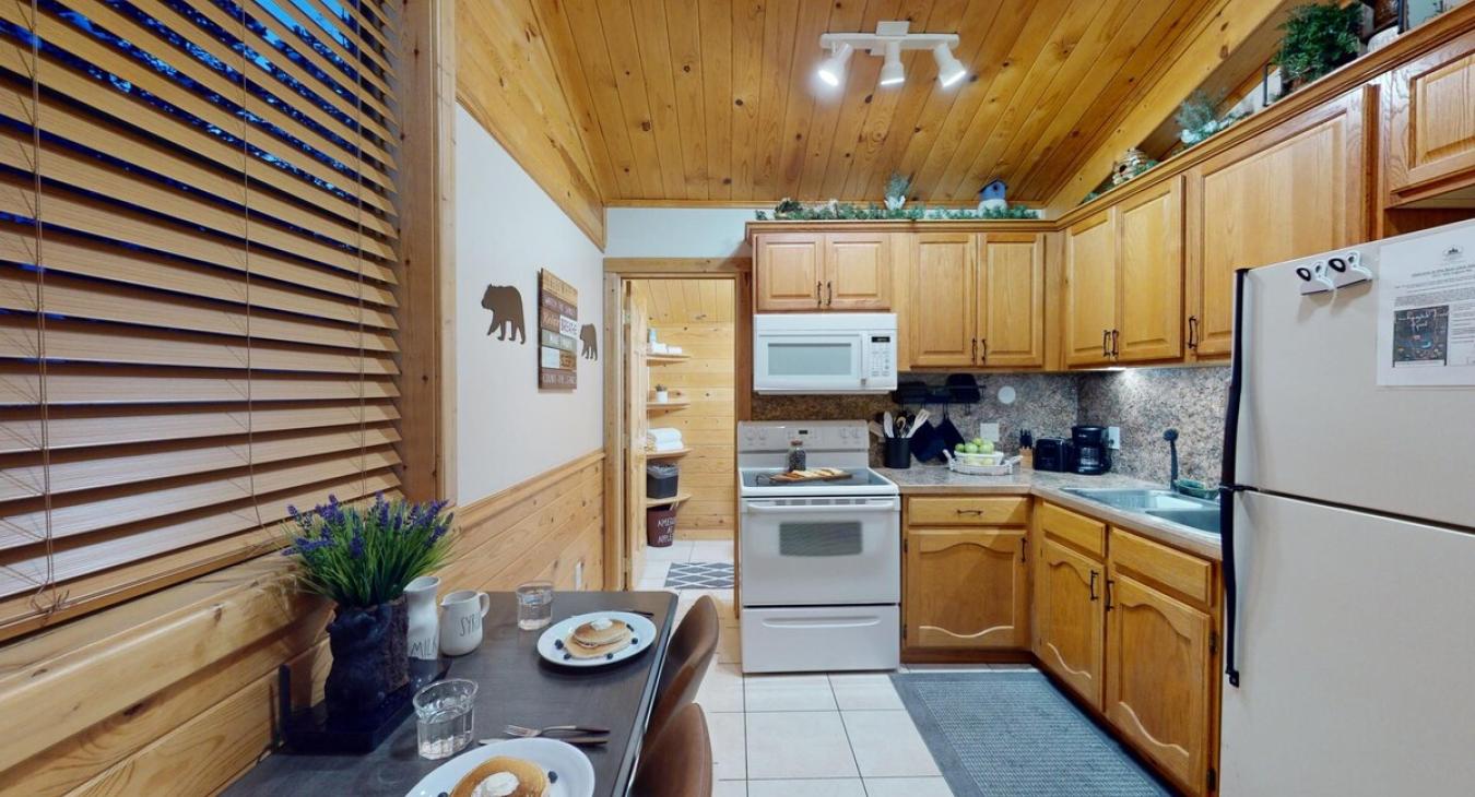 A full kitchen with appliances and dining table to enjoy.