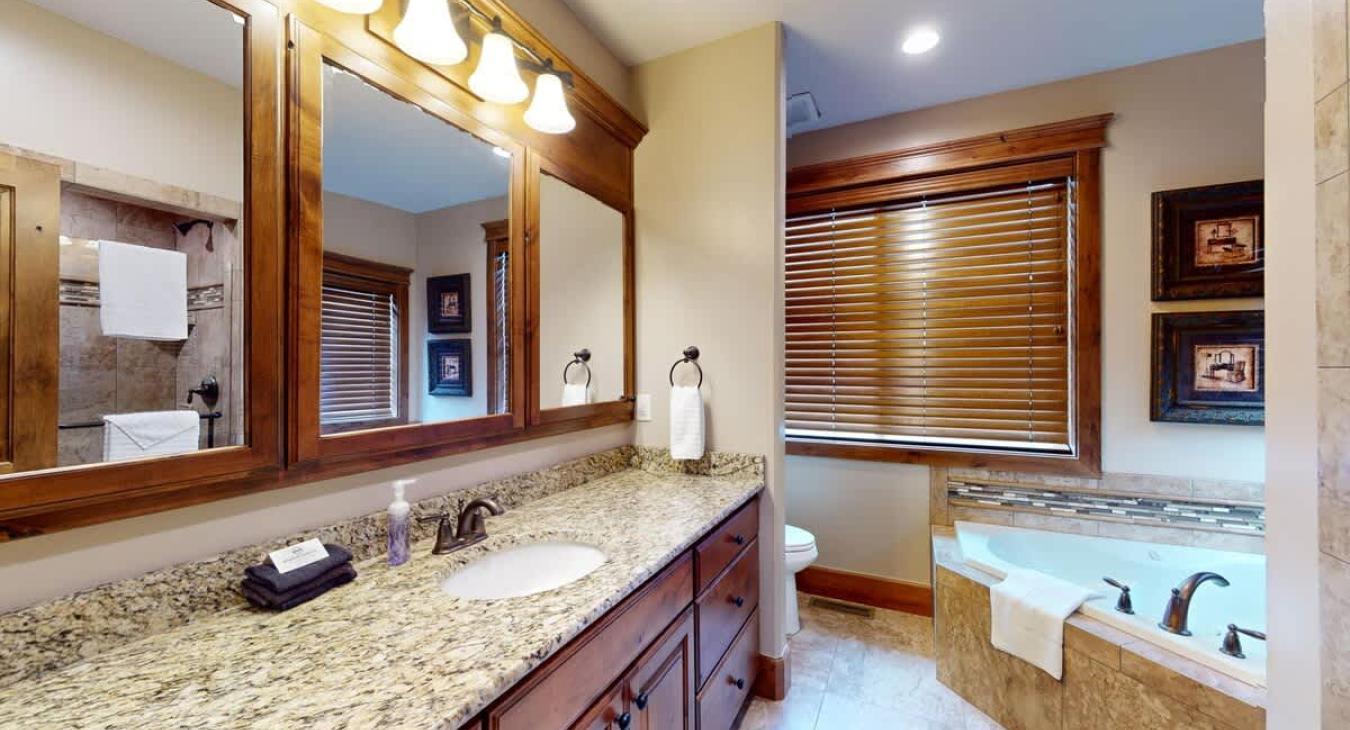Ensuite bathroom with soaking tub, toilet, sink vanity, and walk in shower.