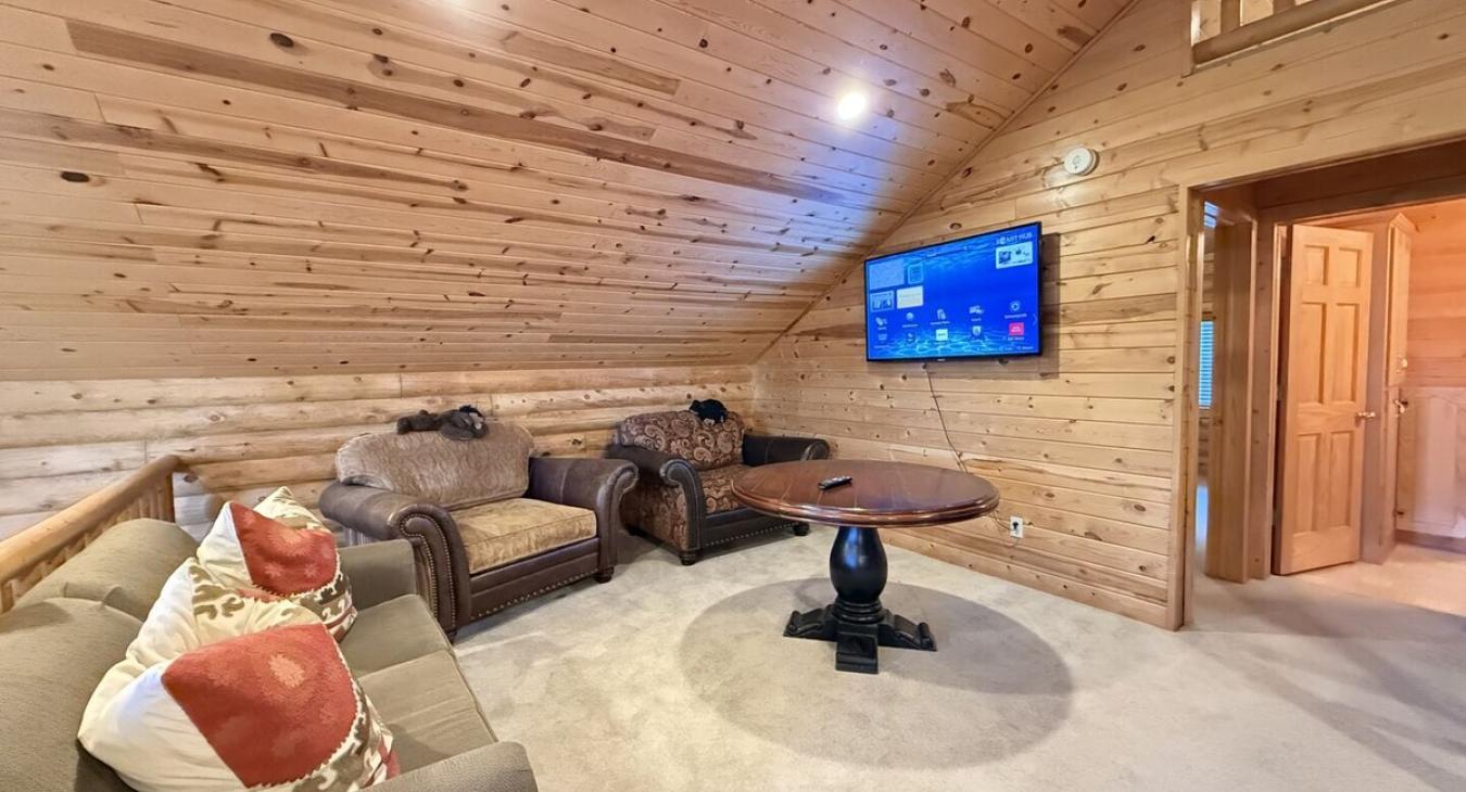 Upstairs loft with tv and seating.