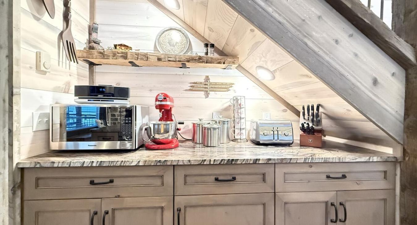 Kitchen rear counter space with microwave and kitchenaid mixer.