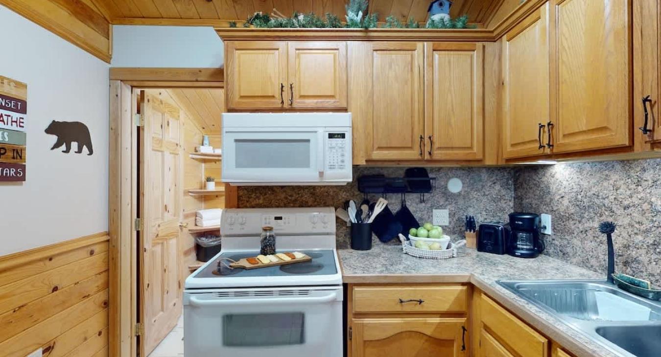 Kitchen equipped with a stove, oven, and microwave along with basic kitchen essentials.