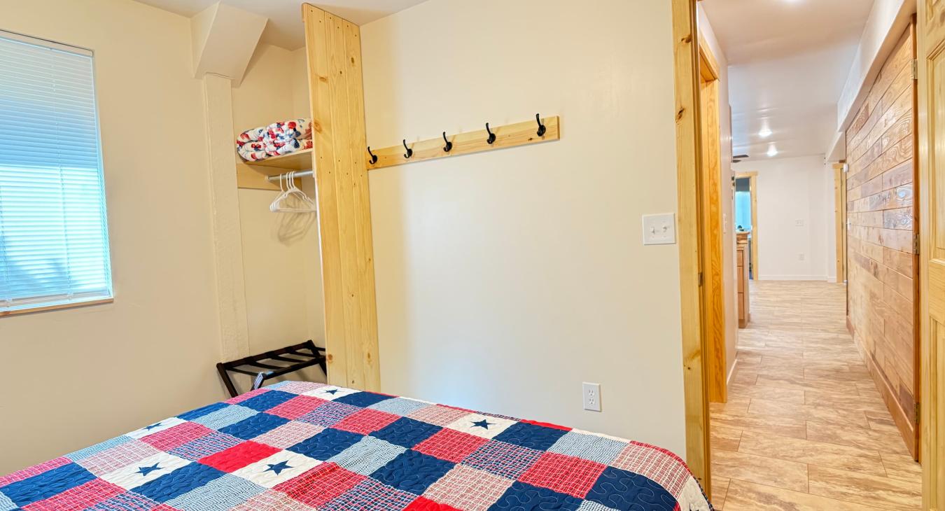 Master bedroom with a queen bed. Closet and hallway view.