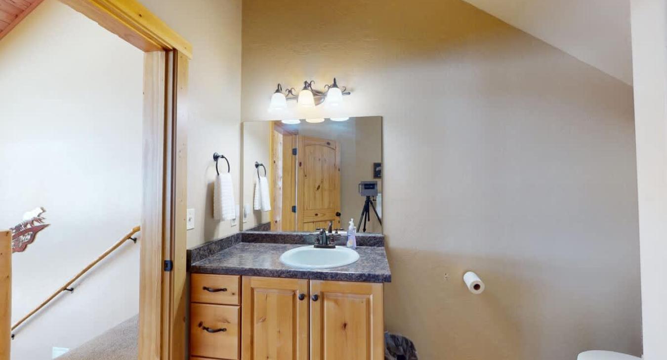 Shower tub combo, toilet, and sink vanity with storage.