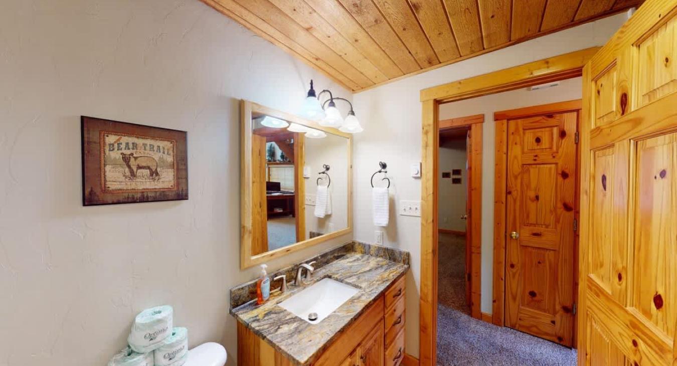 Bathroom equipped with shower tub combo, toilet, and sink vanity.