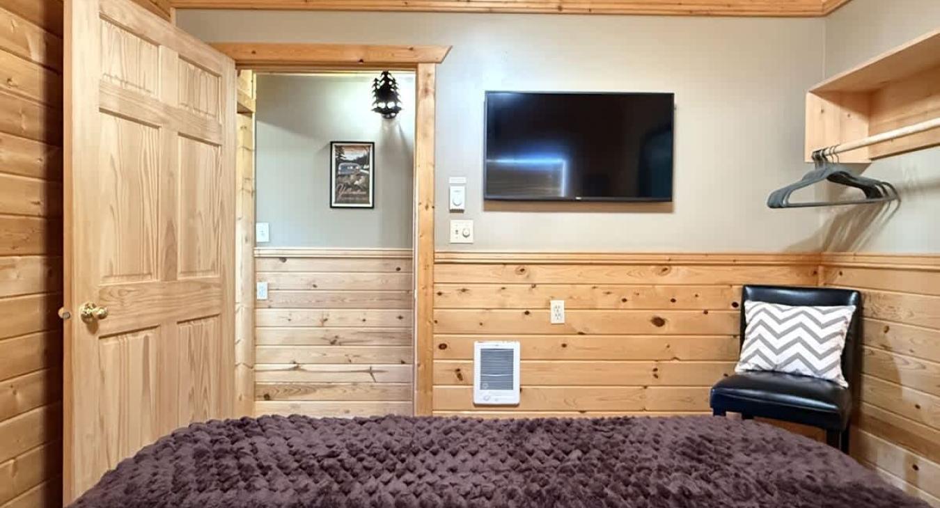 Across from the bed is a flat-screen TV—simple, unobtrusive, ready for late-night movies or quiet mornings.