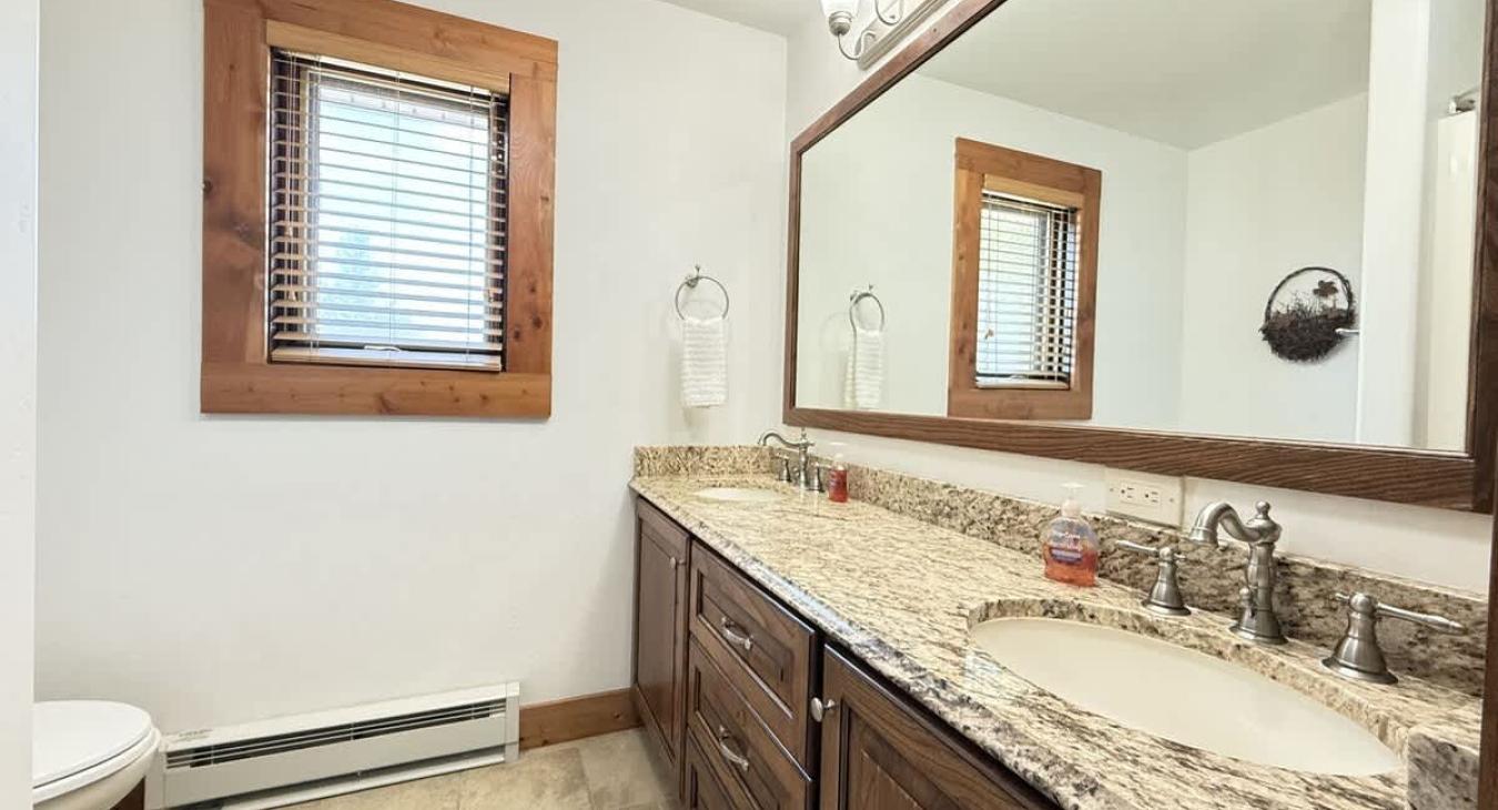 Bathroom #3 located upstairs equipped with shower/tub, toilet, and double sink.