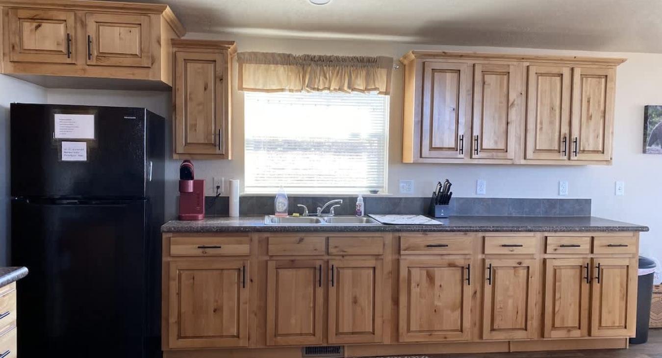 Kitchen with appliances, basic cooking essentials, dishes, silverware, and basic spices.