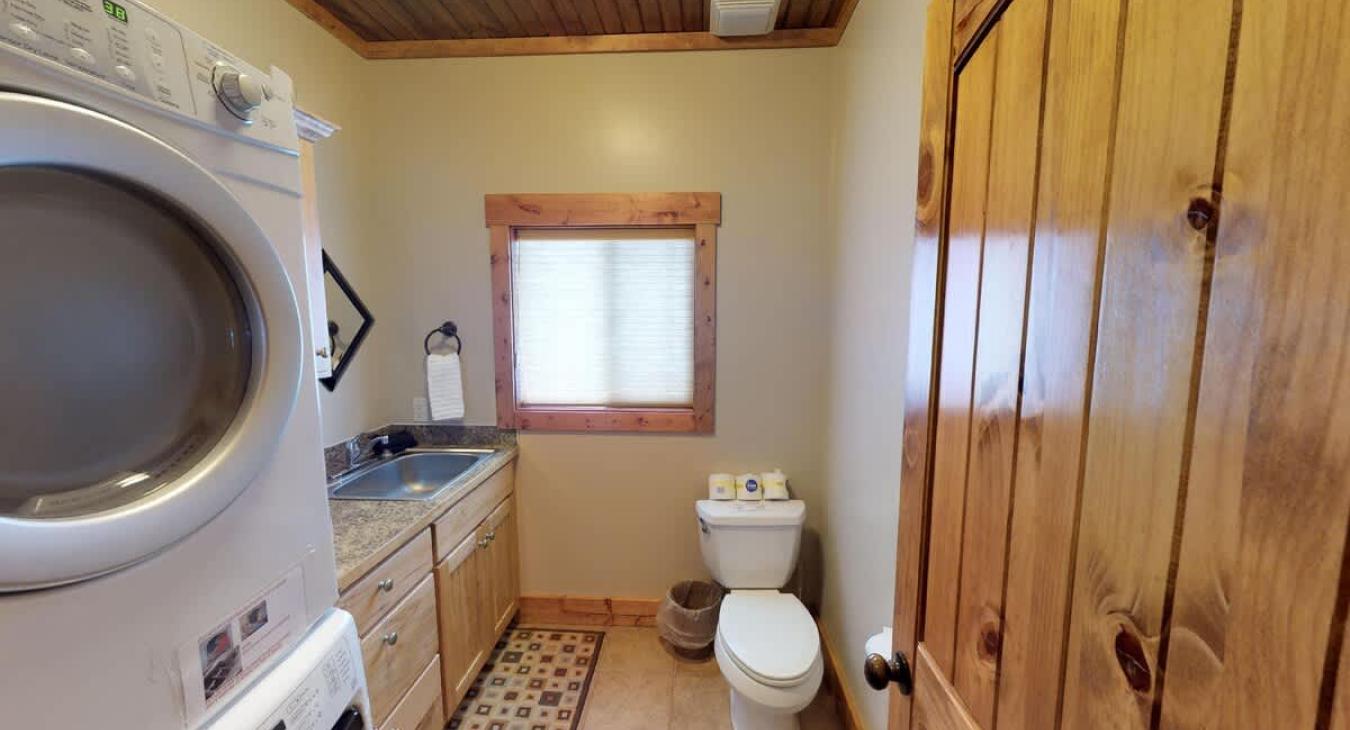 A half bathroom is located on the main floor with a toilet, sink, and stacked washer and dryer.