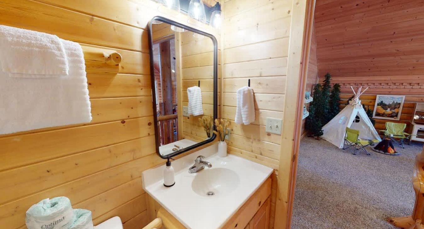 Shared upstairs bathroom with a shower tub combo, toilet, and sink vanity.