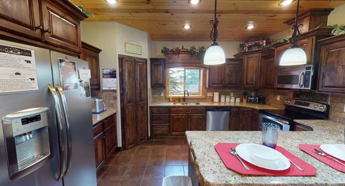 Beautiful kitchen equipped with stainless steel appliances, pots and pans, dishes, silverware, and basic cooking essentials.