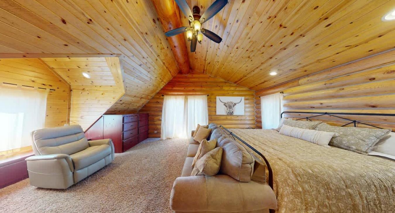 A comfortable couch sits along below the bed, offering a relaxing spot to unwind or enjoy a good book.