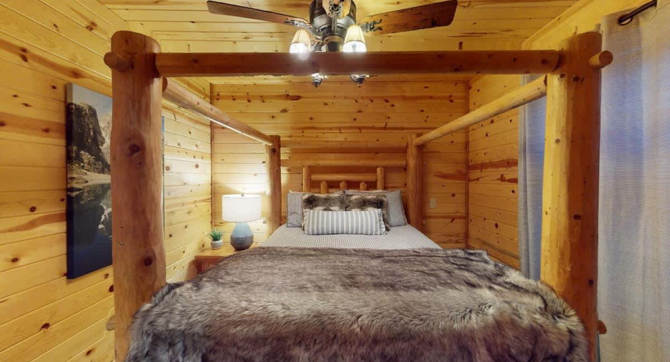 At the center of the room is a queen-sized bed with bedside table located on both sides.