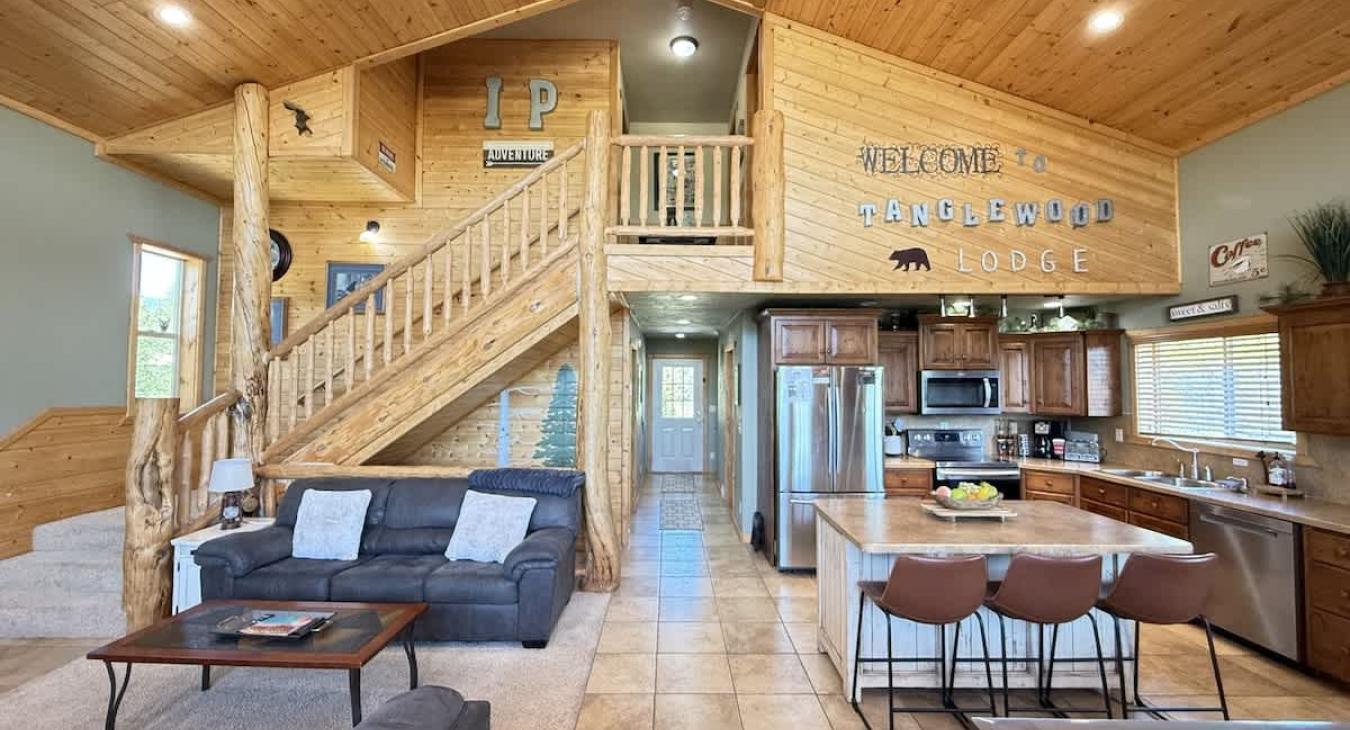 Access to the third level is up the stairs. The open kitchen blends seamlessly into the cabin's cozy living area, creating a welcoming space perfect for gathering and unwinding.