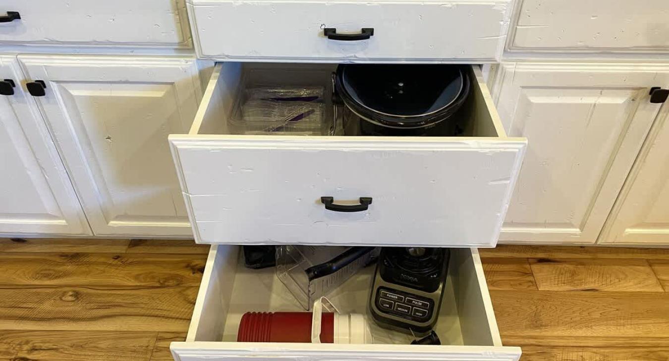 The cabinets may feature pull-out drawers for easy access to smaller appliances like a blender and crockpot.
