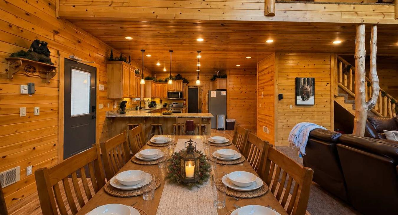 Host unforgettable group dinners at the grand wooden dining table, beautifully set under a warm lantern centerpiece and connecting seamlessly to the living space.
