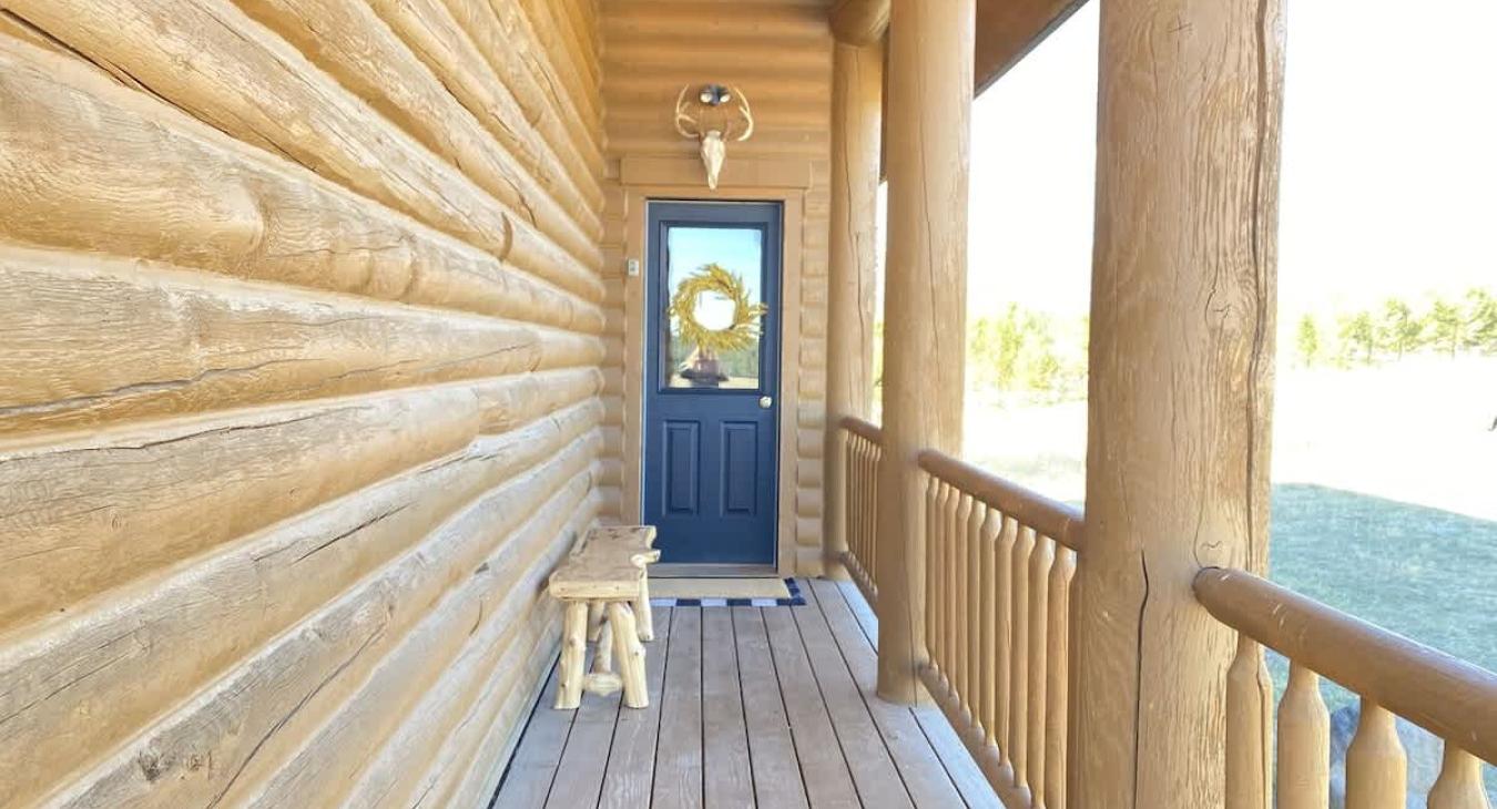 The porch wraps around the whole cabin.