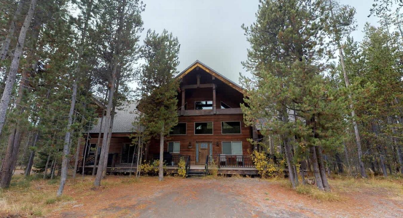 Nestled in the trees is this beautiful handcrafted log cabin.