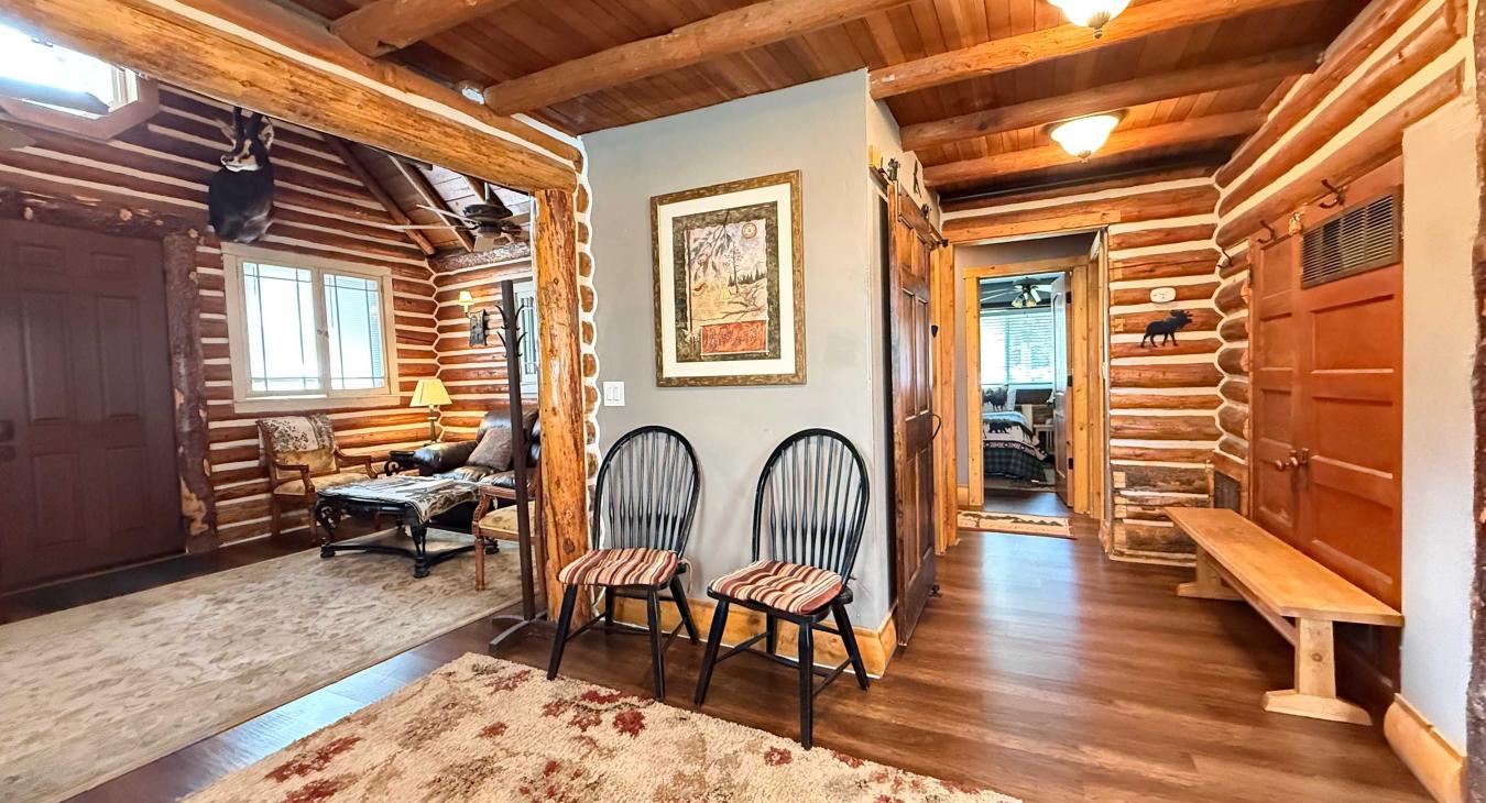 The warm and welcoming entryway features smooth hardwood floors, cozy bench seating, and classic rustic decor that makes you feel right at home.