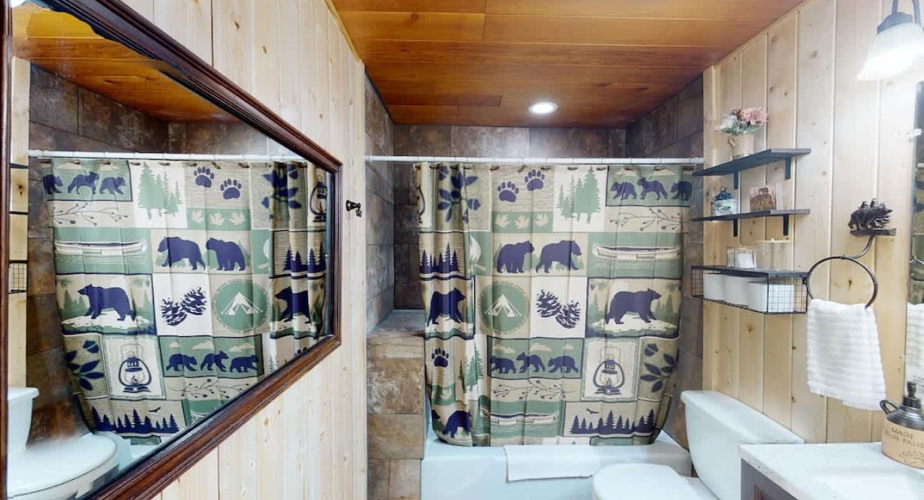 Full bathroom with a shower tub combo, sink vanity, and a toilet.