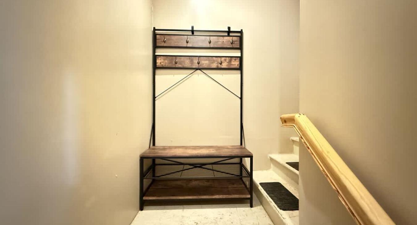 coat and shoe bench on the landing at the top of the stairs