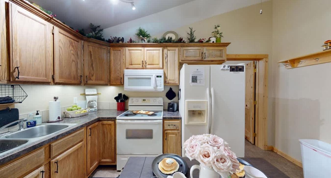 A full size kitchen with a dining room table to seat everyone.