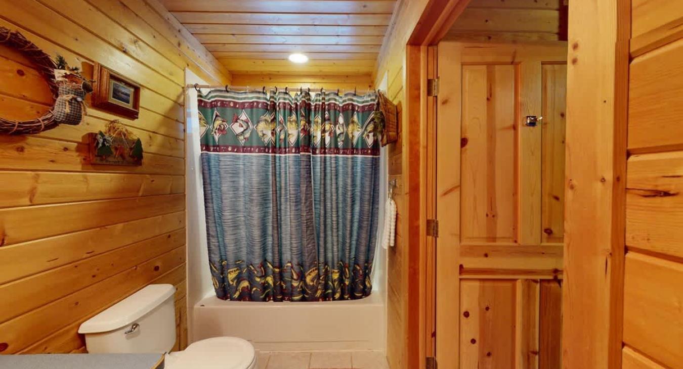 Upstairs bathroom with shower/tub, toilet, and sink.