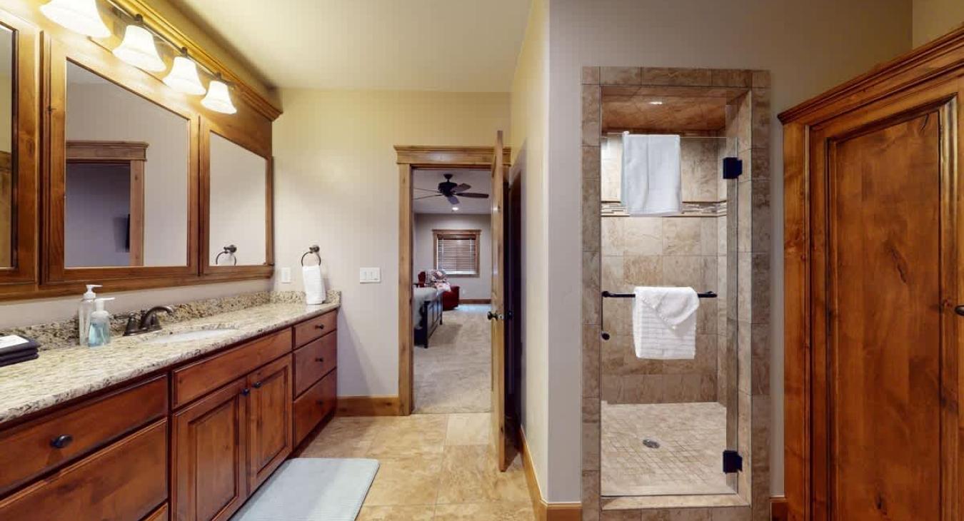 Upstairs ensuite bathroom with walk in shower, toilet, and sink vanity.