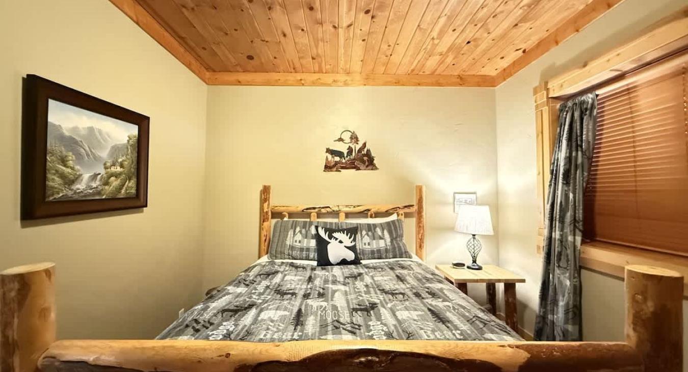 Bedroom #3 located in the basement with a queen bed right off the living room.