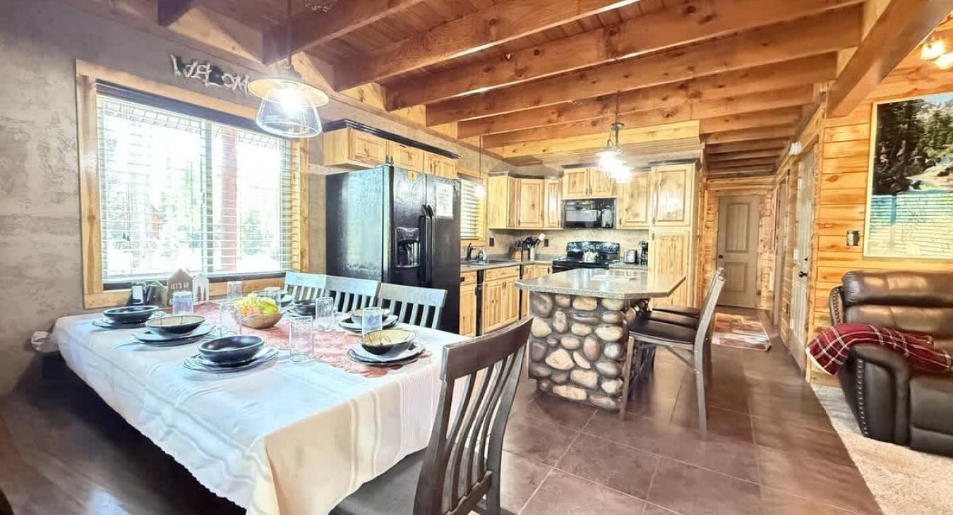 The open kitchen blends seamlessly into the cabin's cozy living area, creating a welcoming space perfect for gathering and unwinding.