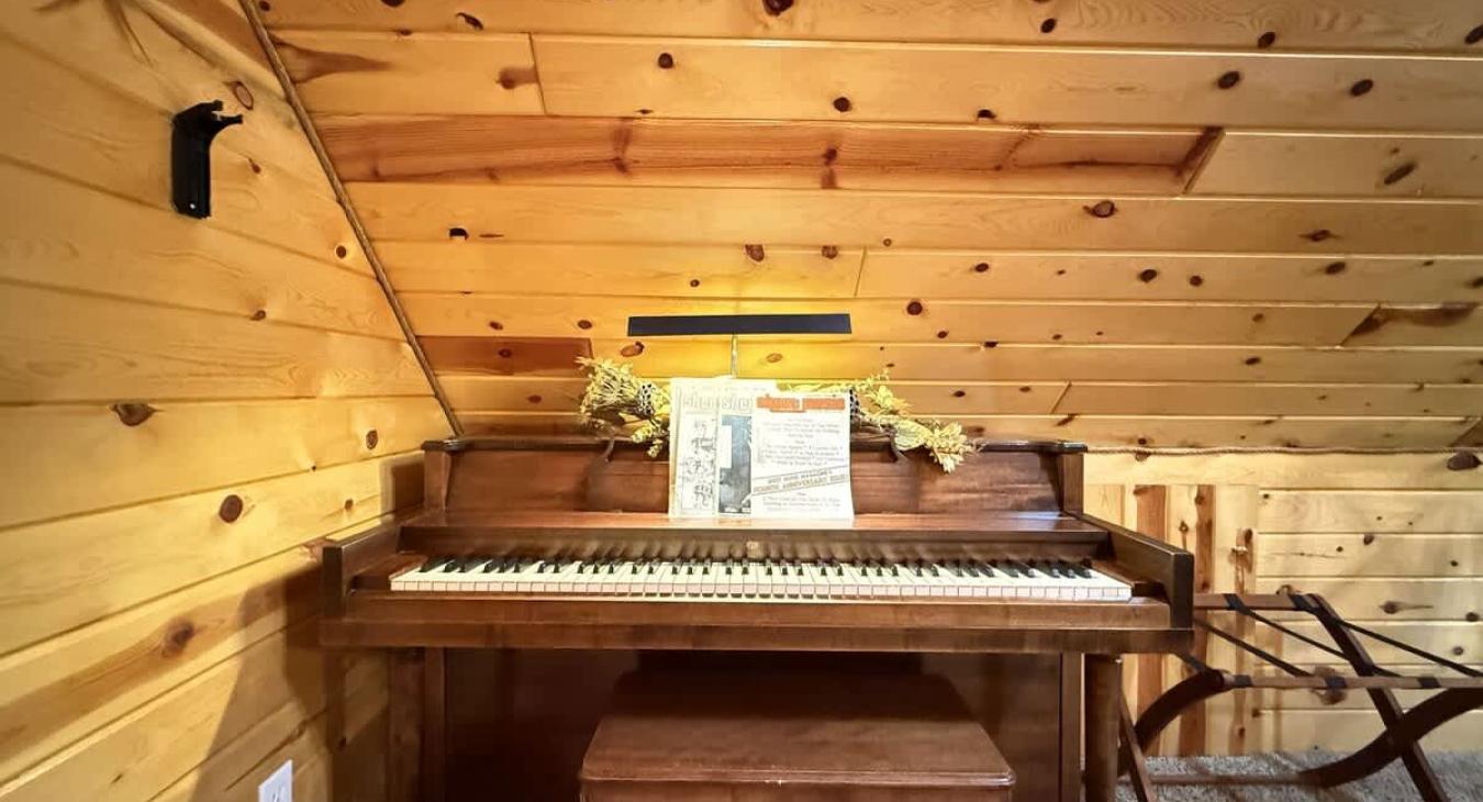 Upstairs loft corner with piano and seating.