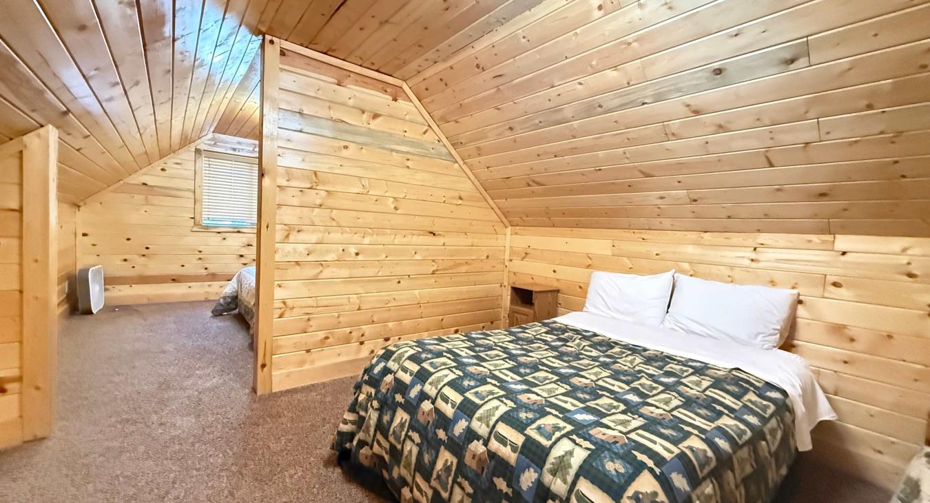 The private sleeping space over the garage offers great flexibility, complete with two cozy beds styled with matching rustic quilts.