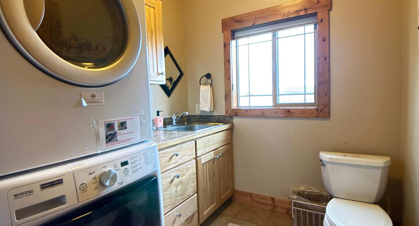 Convenient main-floor half bath equipped with a high-capacity stacked washer and dryer, making quick vacation laundry a breeze.