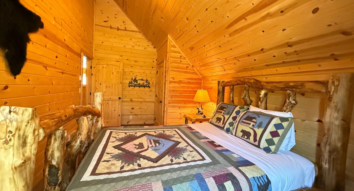 A private mountain sanctuary—perfectly combining rustic log cabin charm with premium comfort, highlighted by an authentic wilderness patchwork quilt.