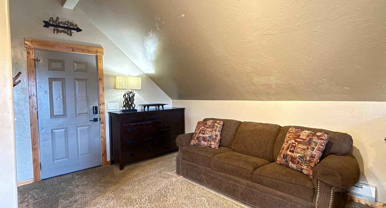 Beside the beds is a comfortable couch for seating others, creating an inviting spot to gather, read, or plan your day's adventures.
