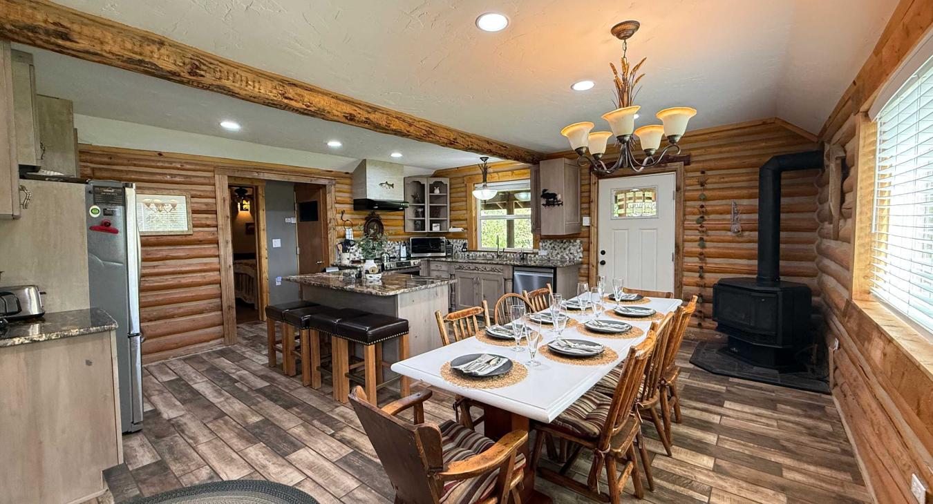 Gather everyone together at the grand dining table, beautifully lit by an elegant country chandelier and warmed by the cozy wood-burning stove nearby.