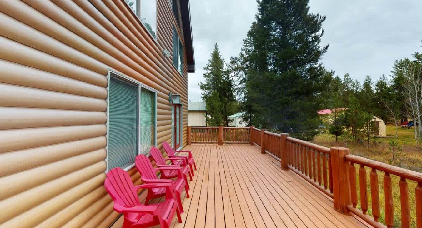 Soak in the fresh mountain air on the expansive open sun deck, featuring vibrant red Adirondack chairs that offer front-row seats to the cabin’s scenic scenery.
