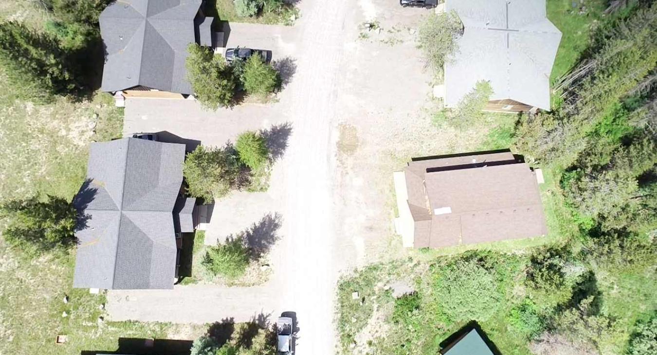 The overhead drone view showcases the cabin's excellent positioning with easy road access, while maintaining a private and relaxing mountain retreat feel.