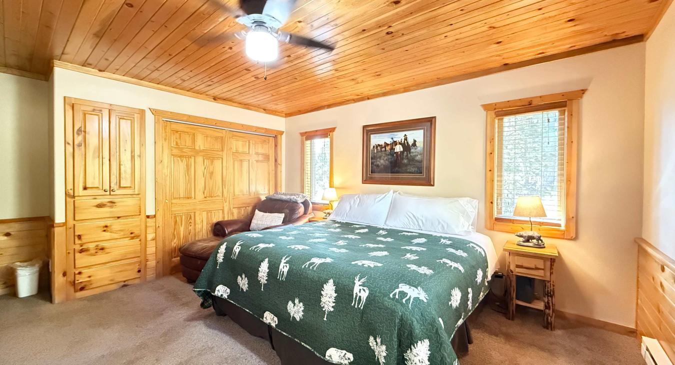 Master bedroom with a King size bed, armchair, and television.