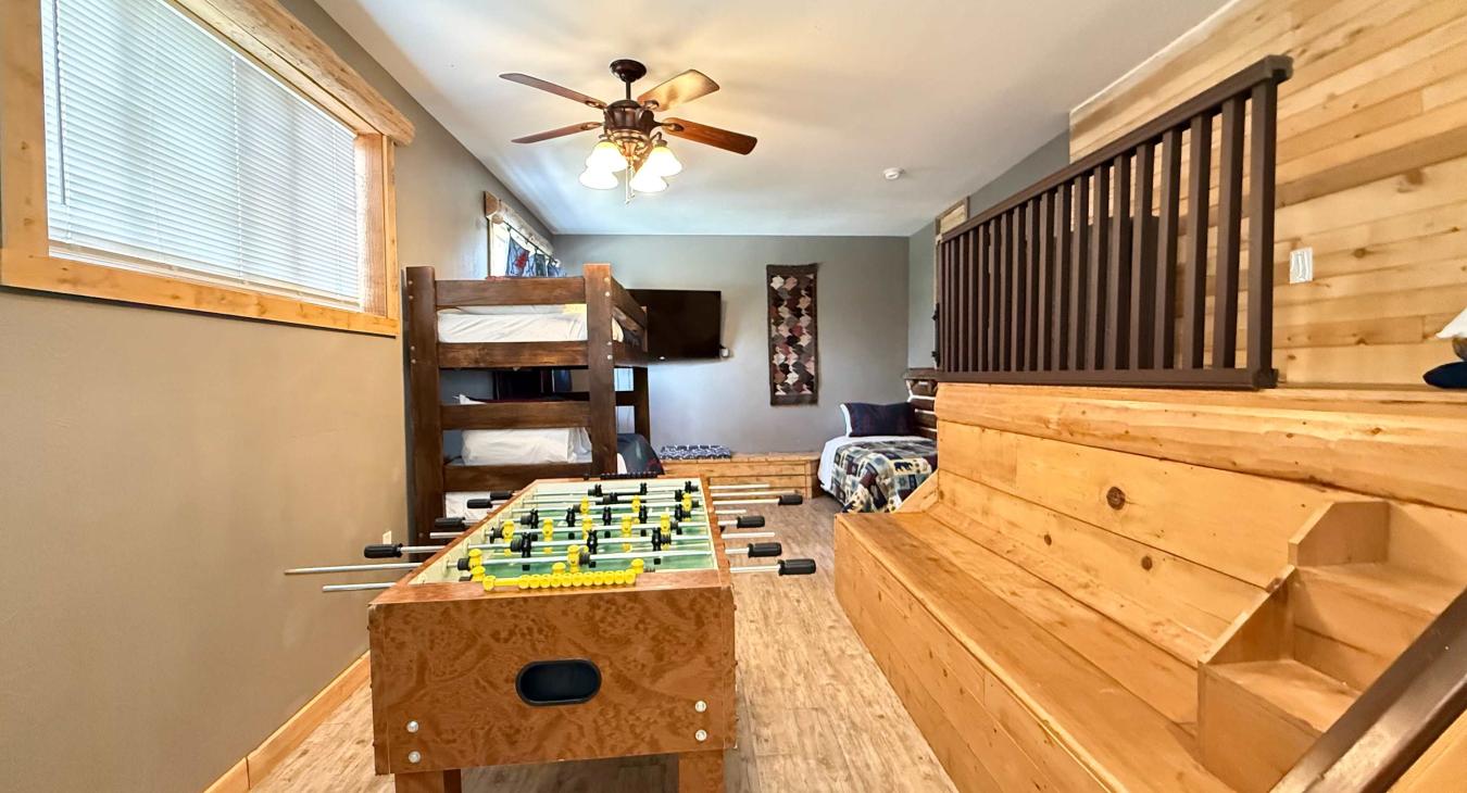 This expansive entertainment loft uniquely combines sleeping options with endless fun, featuring stadium-style wooden bench seating.