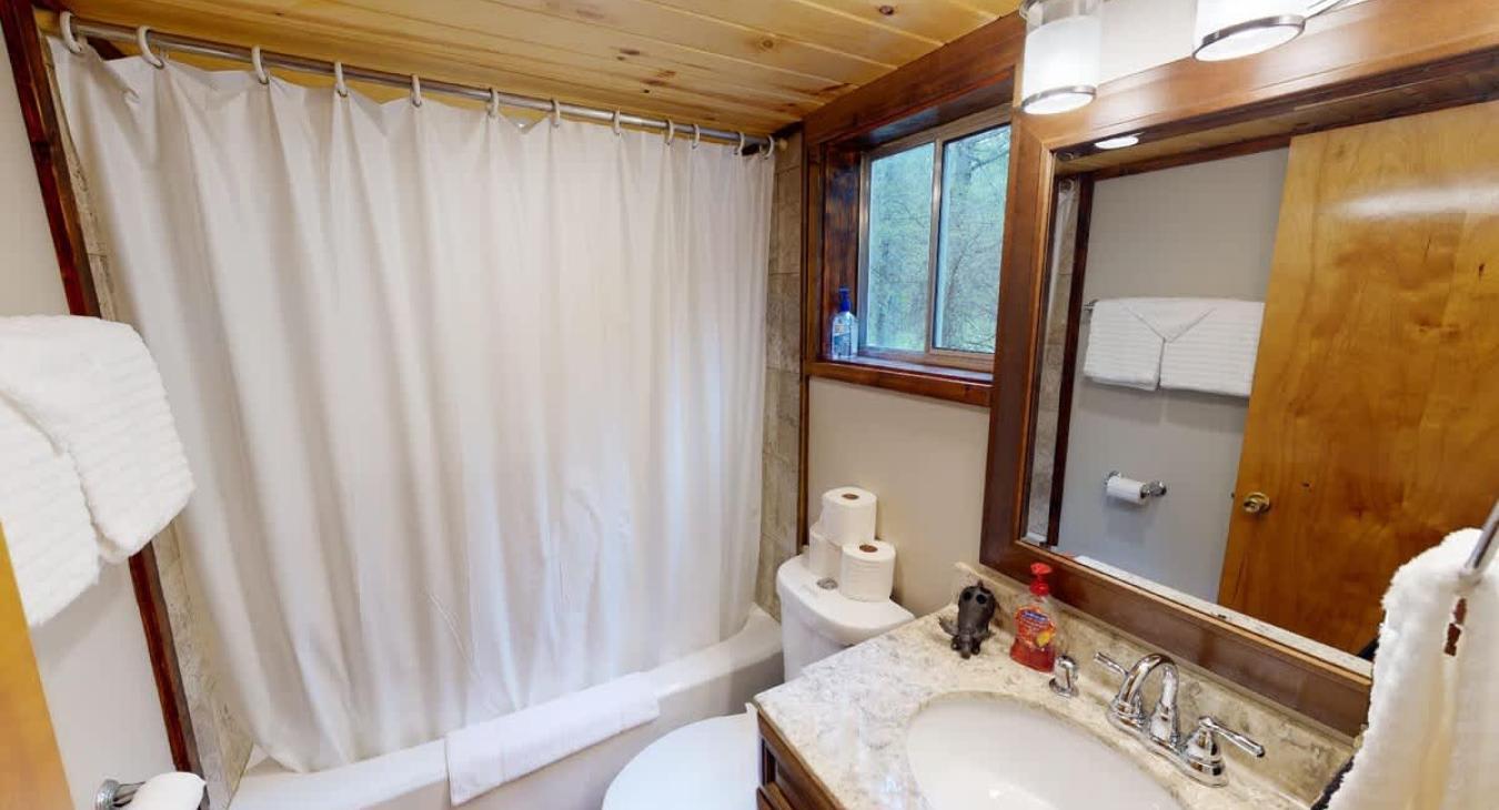 Second bathroom is equipped with a shower tub combo, toilet, and sink vanity.