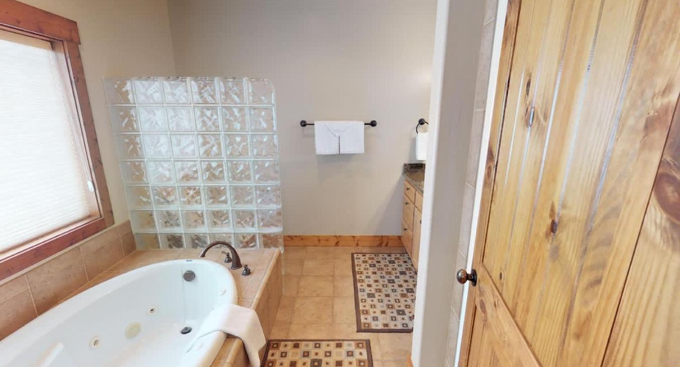 Indulge in the private master ensuite, complete with a grand soaking tub and a sleek glass-block shower for a spa-like escape.