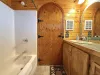 Main level full bathroom with shower, toilet, and sink vanity.