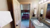 Bathroom is equipped with shower tub combo, toilet, and sink vanity.