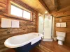 Main level bathroom with standing shower, tub, toilet, and sink.