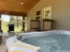 Hot tub and grill are conveniently located outside in the back of the cabin.